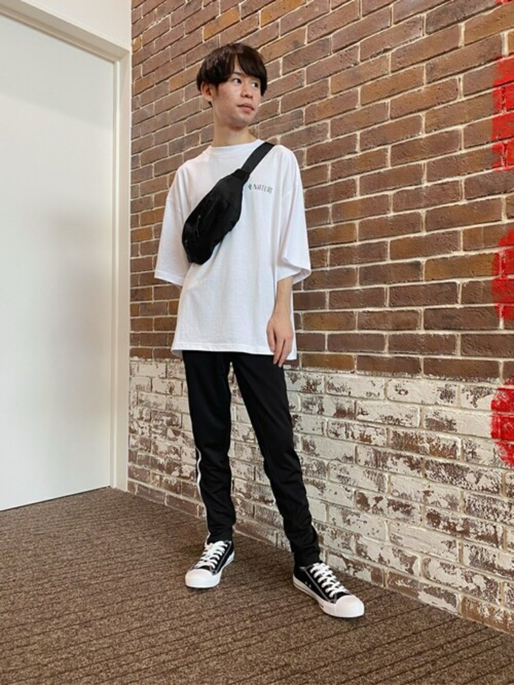 ホワイト系のTシャツ/カットソー、ブラック系のボディバッグ/ウエストポーチ、ブラック系のスウェットパンツを着用したメンズの夏コーディネートの1枚目の写真