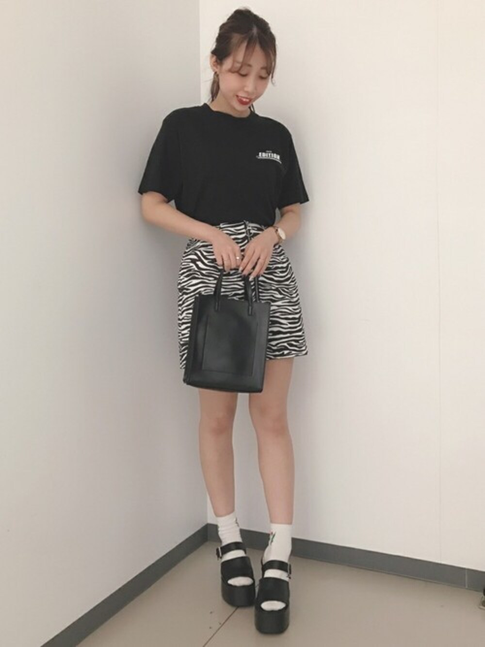 ブラック系のTシャツ/カットソー、ブラック系のスカート、ブラック系のサンダルを着用したレディースの夏コーディネートの1枚目の写真