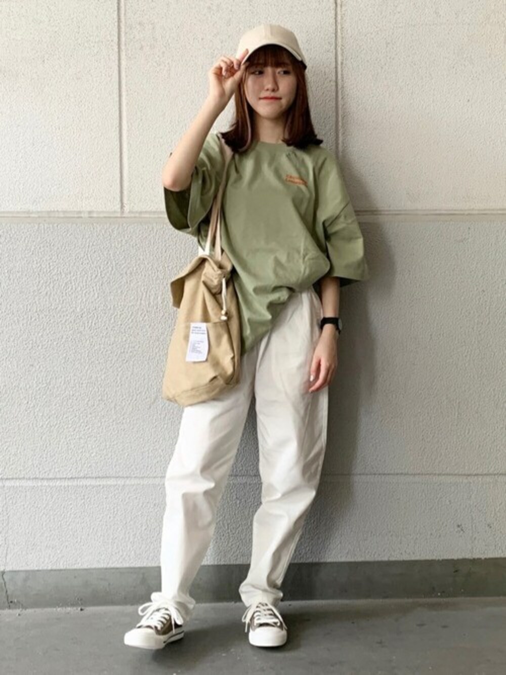 グリーン系のスニーカー、グリーン系のTシャツ/カットソー、ホワイト系のチノパンツを着用したレディースの夏コーディネートの1枚目の写真