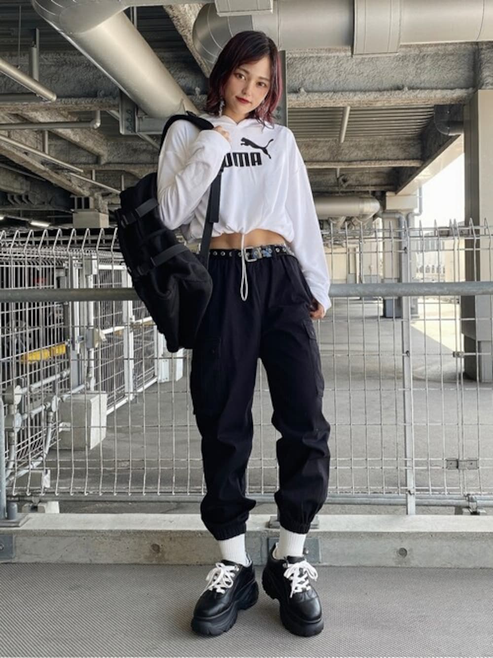 ブラック系のバックパック/リュック、ホワイト系のパーカー、ブラック系のカーゴパンツを着用したレディースの秋コーディネートの1枚目の写真