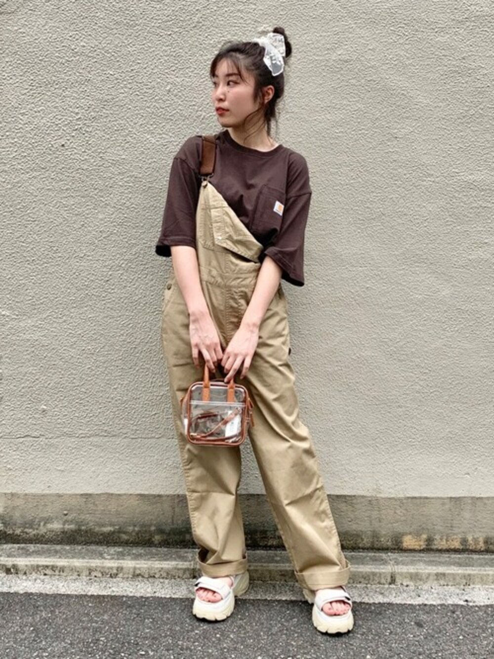 ブラウン系のTシャツ/カットソー、ベージュ系のサロペット/オーバーオール、ベージュ系のサンダルを着用したレディースの秋コーディネートの1枚目の写真