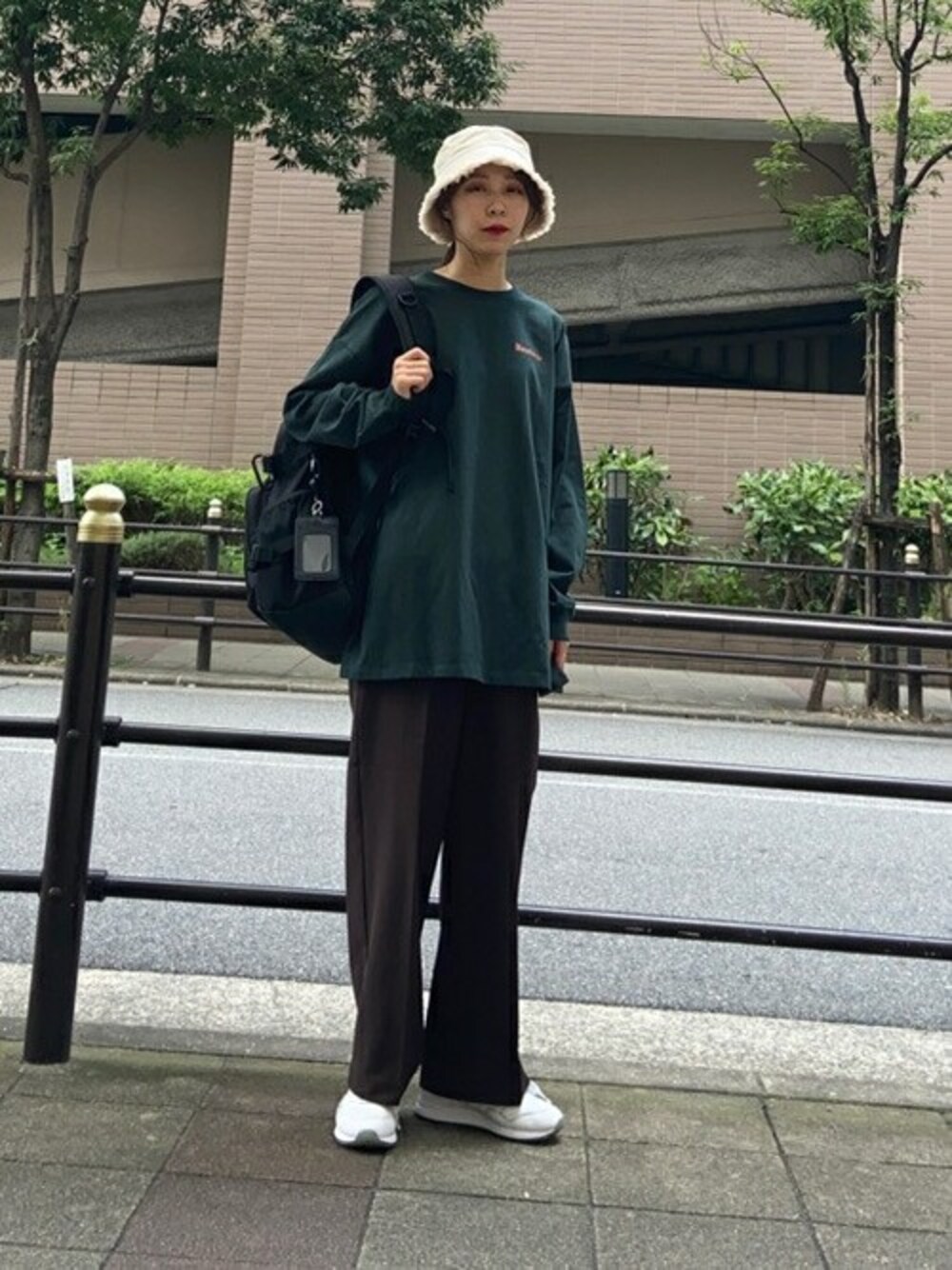 グリーン系のTシャツ/カットソー、ブラック系のバックパック/リュック、ホワイト系のハットを着用したレディースの秋コーディネートの1枚目の写真