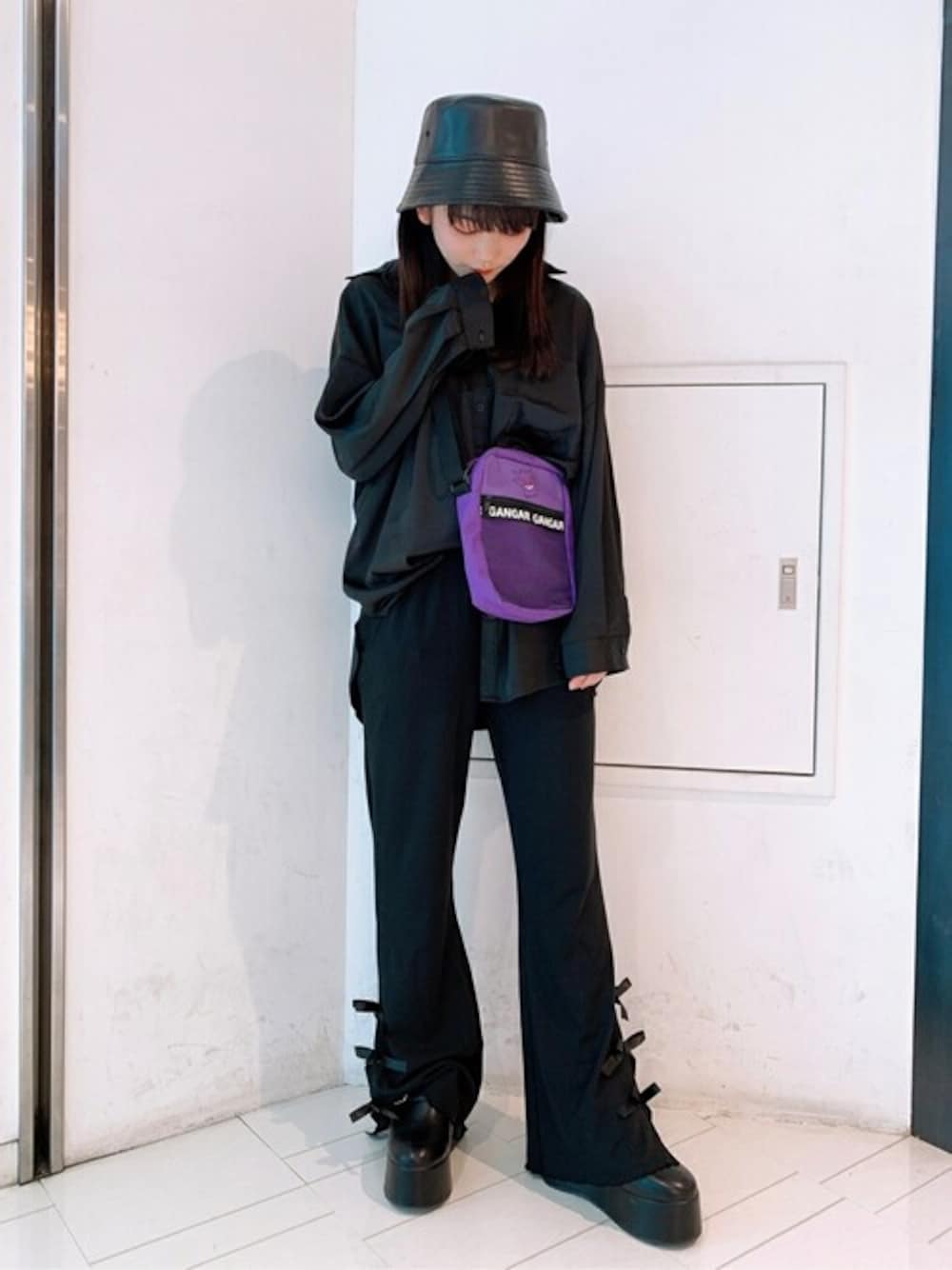 ブラック系のシャツ/ブラウス、ブラック系のスラックス、パープル系のショルダーバッグを着用したレディースの秋コーディネートの1枚目の写真