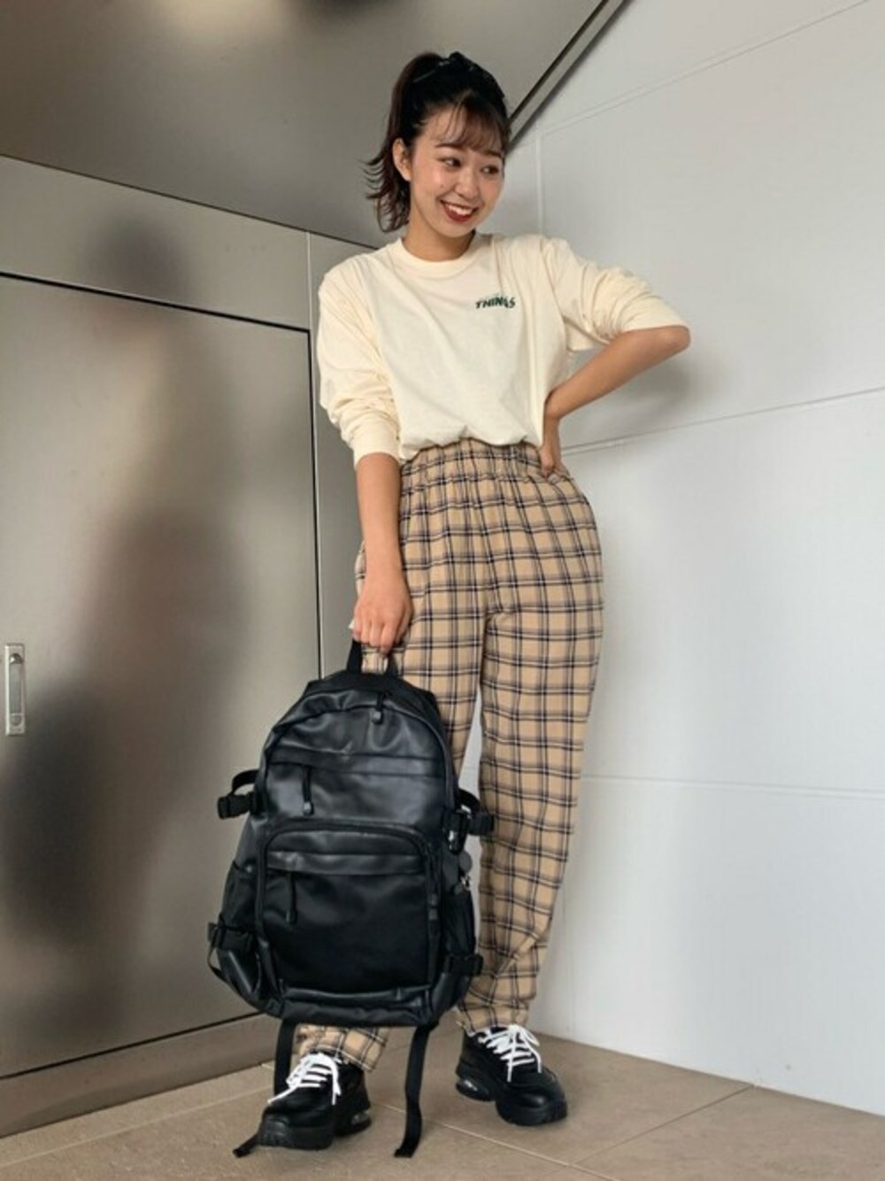 ブラック系のバックパック/リュック、ブラック系のMA-1、ベージュ系のチノパンツを着用したレディースの秋コーディネートの1枚目の写真