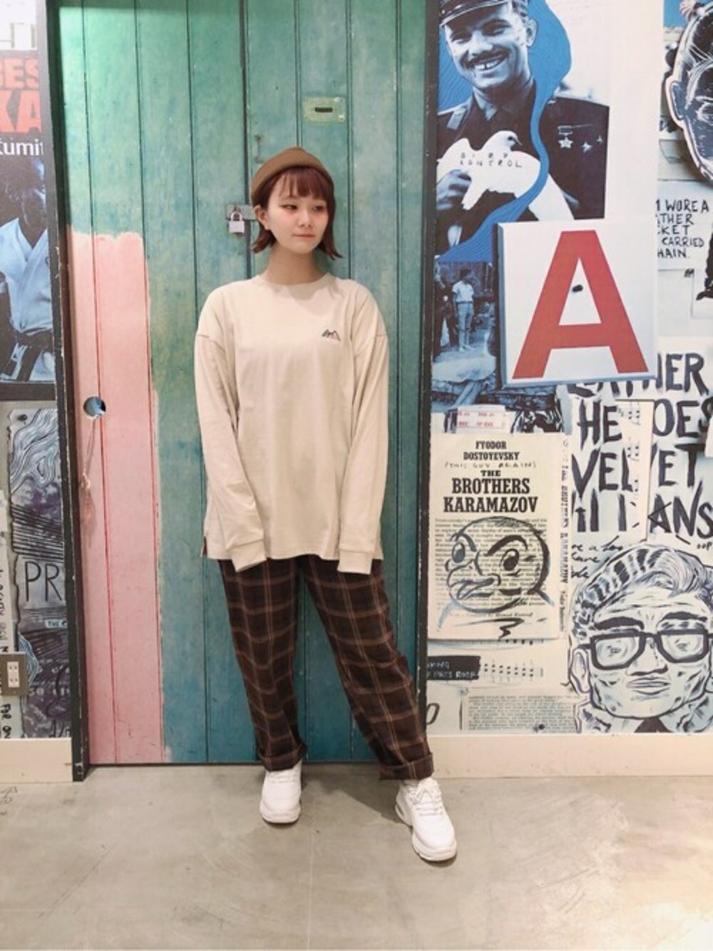 ベージュ系のTシャツ/カットソー、ブラウン系のチノパンツ、ブラウン系のニットキャップ/ビーニーを着用したレディースの秋コーディネートの1枚目の写真