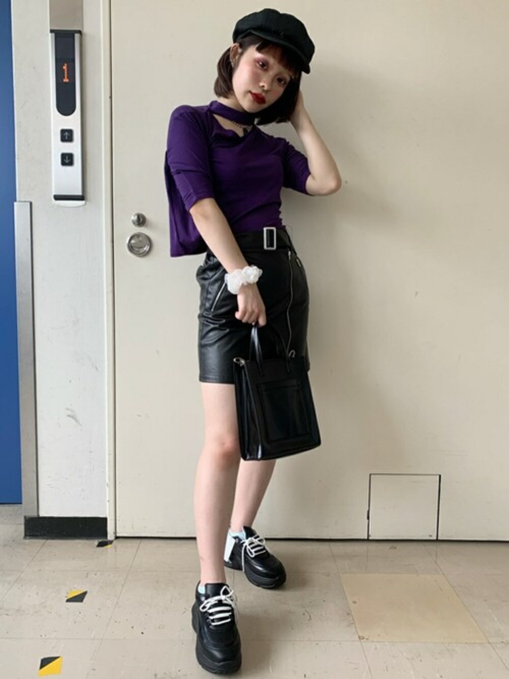 パープル系のTシャツ/カットソー、ブラック系のスカート、ブラック系のトートバッグを着用したレディースの秋コーディネートの1枚目の写真