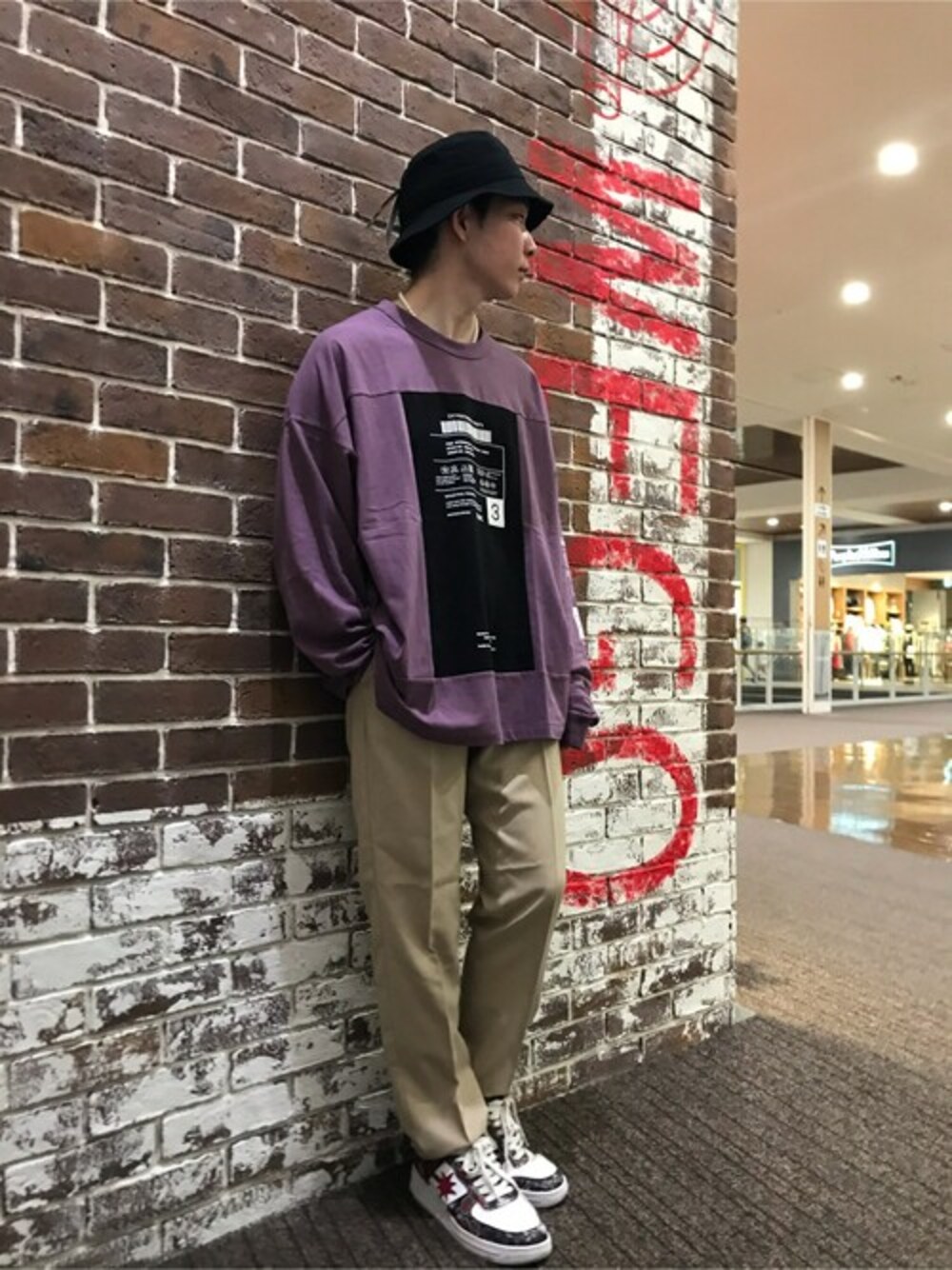 パープル系のTシャツ/カットソー、ベージュ系のスラックス、ブラック系のハットを着用したメンズの秋コーディネートの1枚目の写真