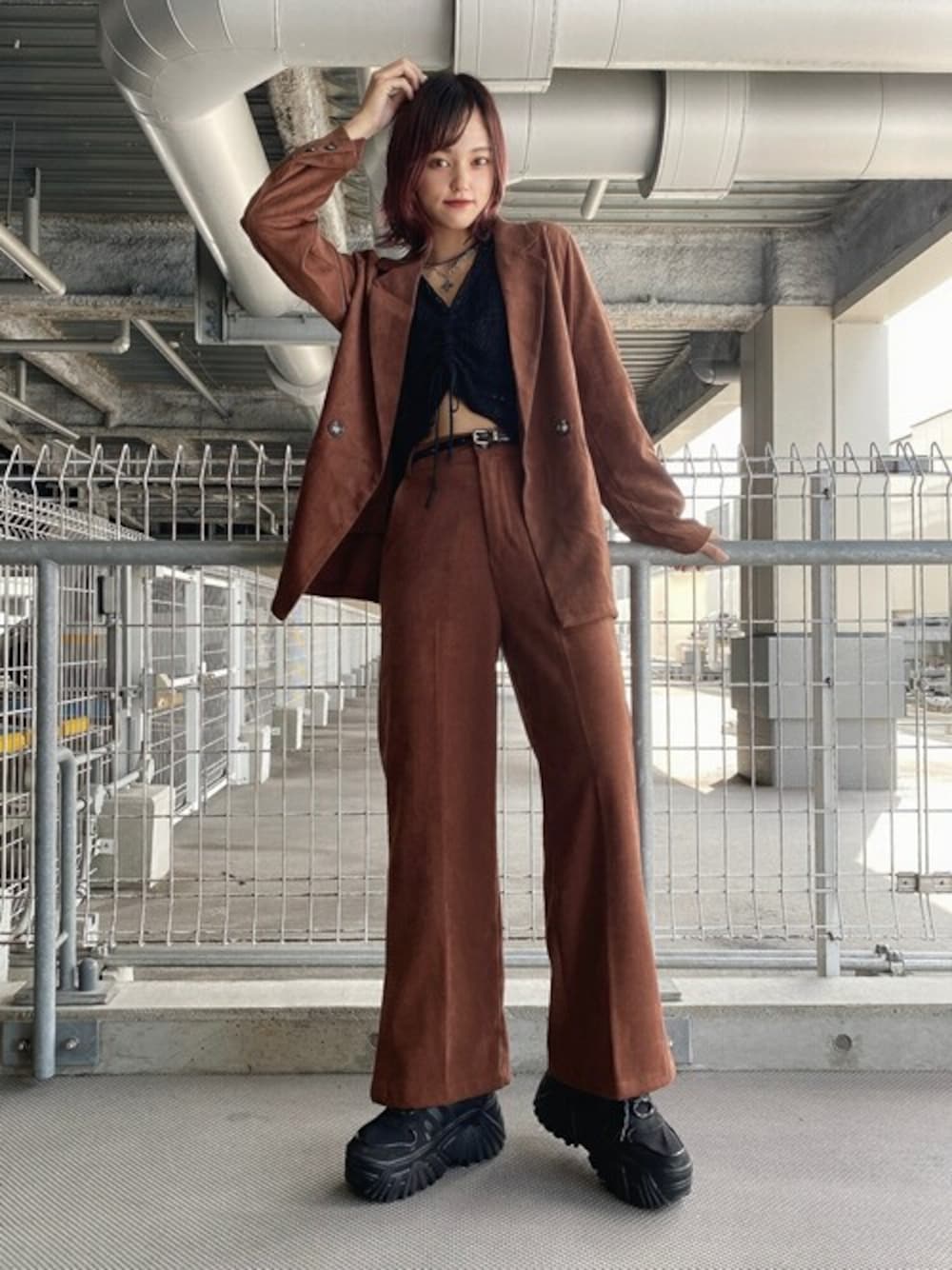 ブラウン系のテーラードジャケット、ブラック系のニット/セーター、ブラウン系のスラックスを着用したレディースの秋コーディネートの1枚目の写真