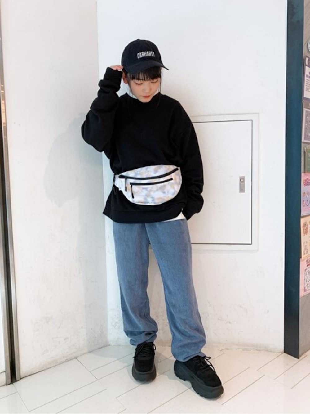 ブラック系のスウェット、ホワイト系のTシャツ/カットソー、ブルー系のスラックスを着用したレディースの秋コーディネートの1枚目の写真