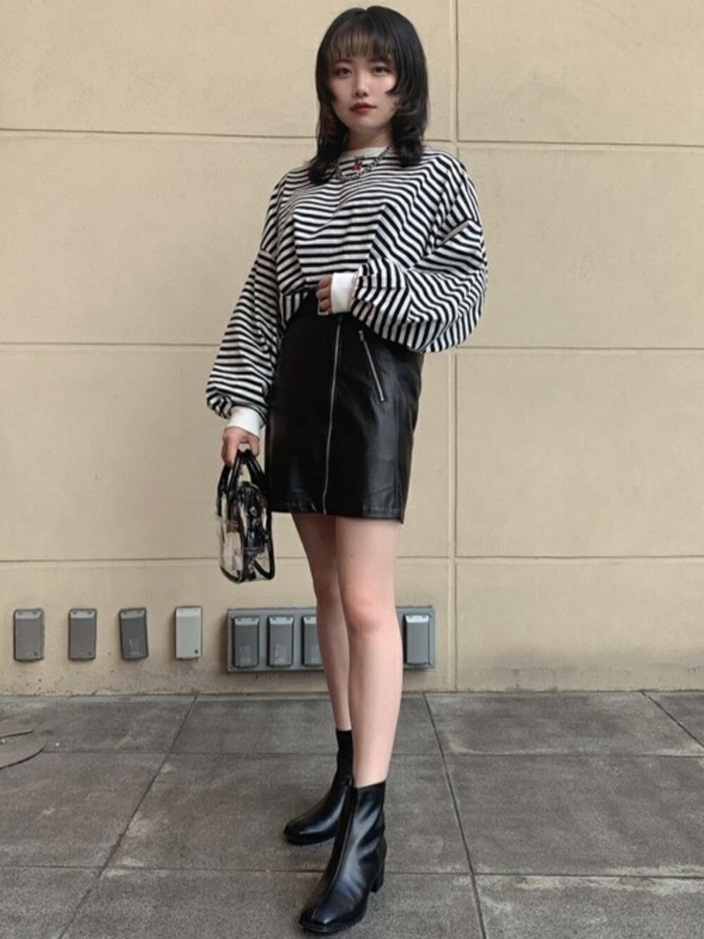 ブラック系のブーツ、ブラック系のTシャツ/カットソー、ブラック系のスカートを着用したレディースの秋コーディネートの1枚目の写真