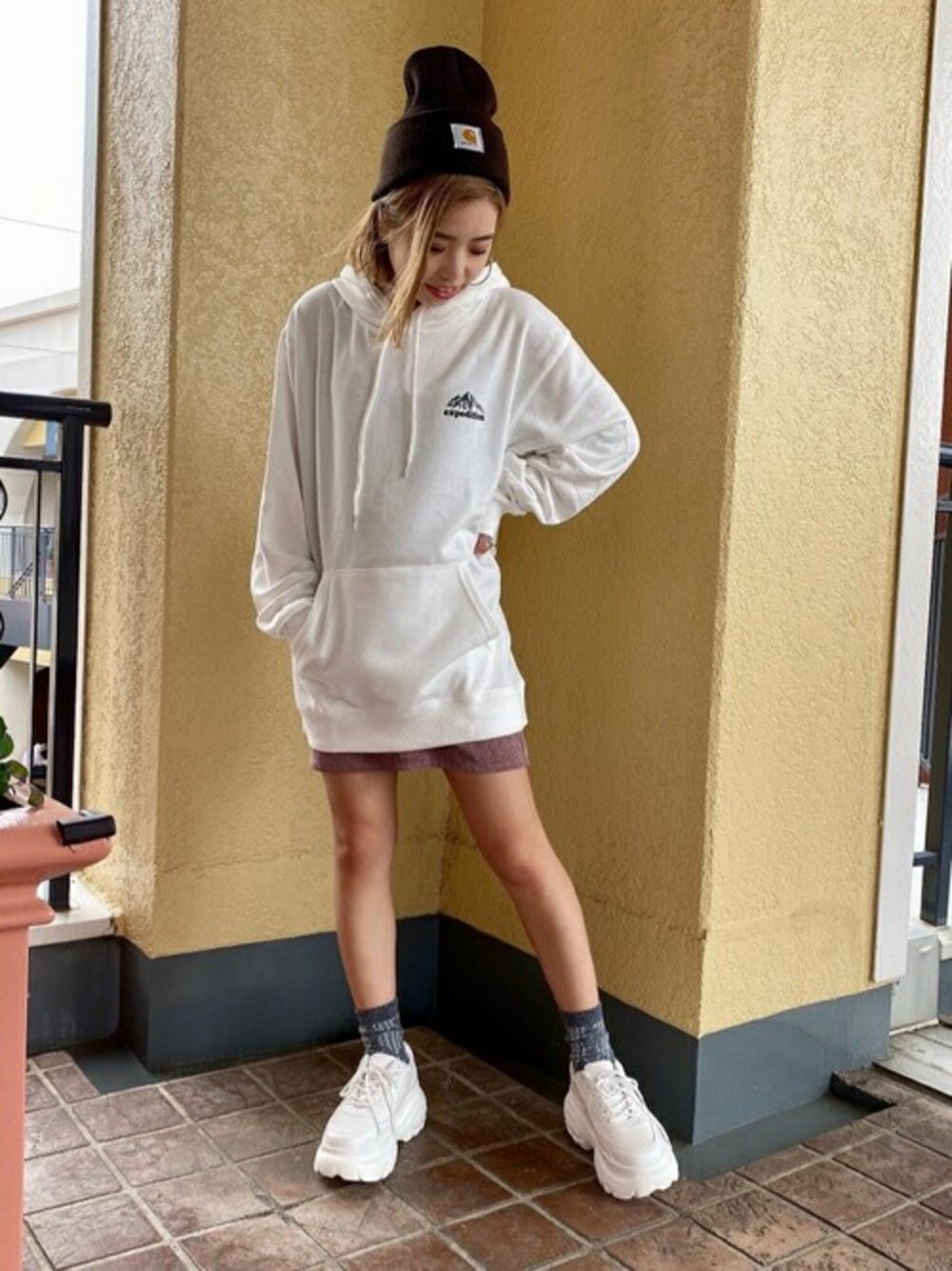 ホワイト系のパーカー、ホワイト系のスニーカー、パープル系のスカートを着用したレディースの秋コーディネートの1枚目の写真