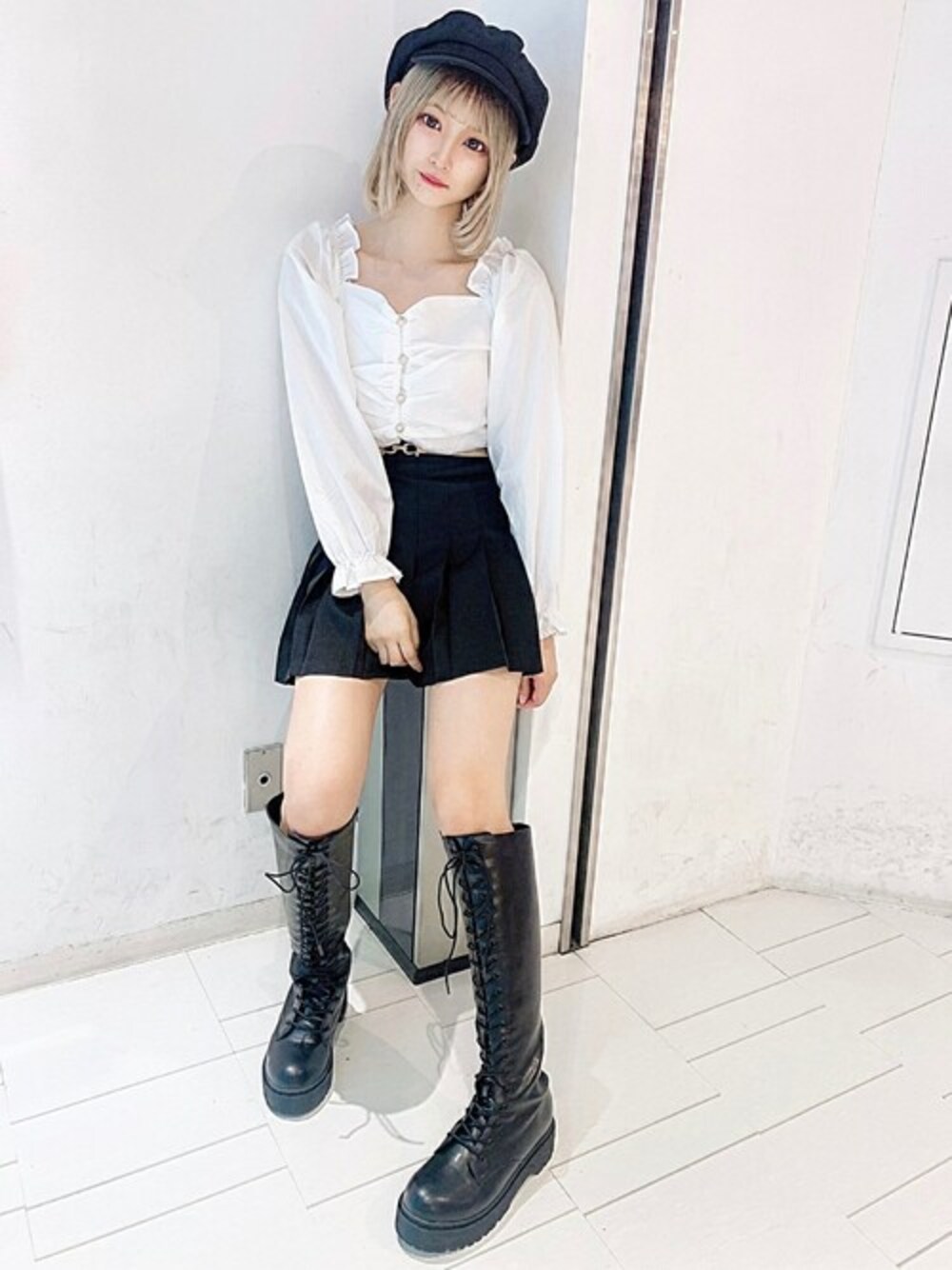 ホワイト系のシャツ/ブラウス、ブラック系のスカート、ブラック系のブーツを着用したレディースの秋コーディネートの1枚目の写真