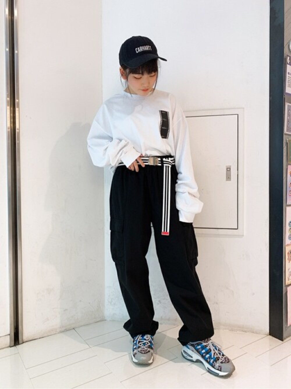 その他のTシャツ/カットソー、ブラック系のチノパンツ、ブラック系のキャップを着用したレディースの秋コーディネートの1枚目の写真
