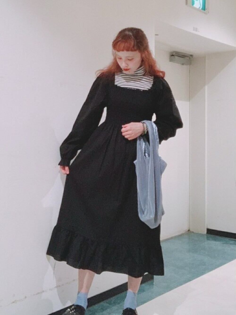 ブルー系のトートバッグ、ブラック系のワンピース、ホワイト系のTシャツ/カットソーを着用したレディースの秋コーディネートの1枚目の写真