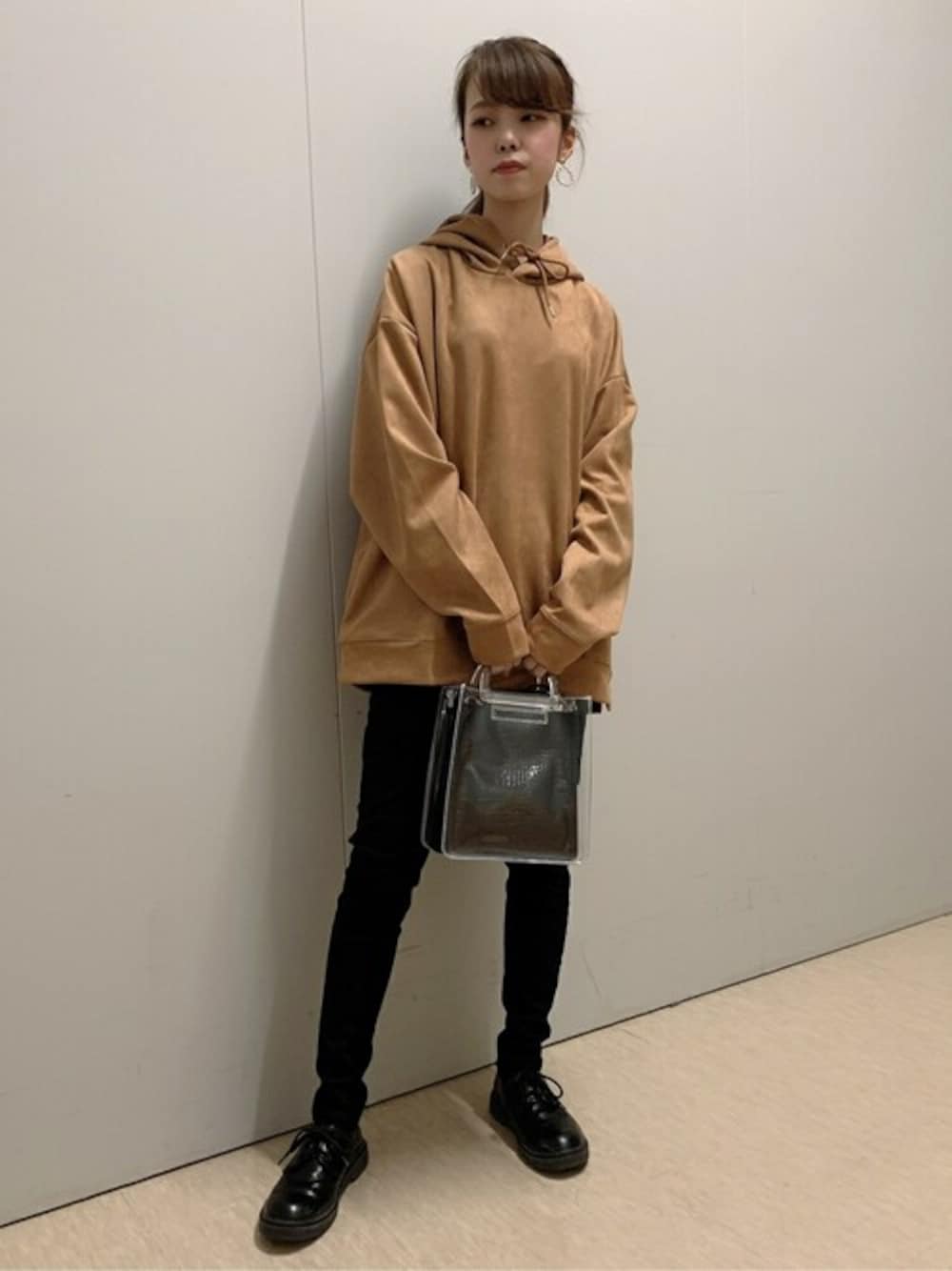 イエロー系のパーカー、ブラック系のデニムパンツ、その他のショルダーバッグを着用したレディースの秋コーディネートの1枚目の写真