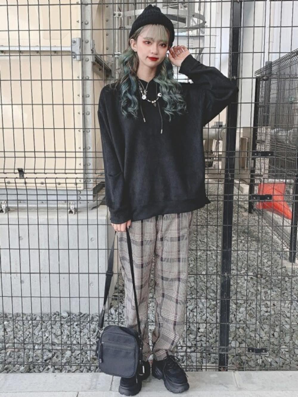 ブラック系のパーカー、ベージュ系のスラックス、ブラック系のスニーカーを着用したレディースの秋コーディネートの1枚目の写真