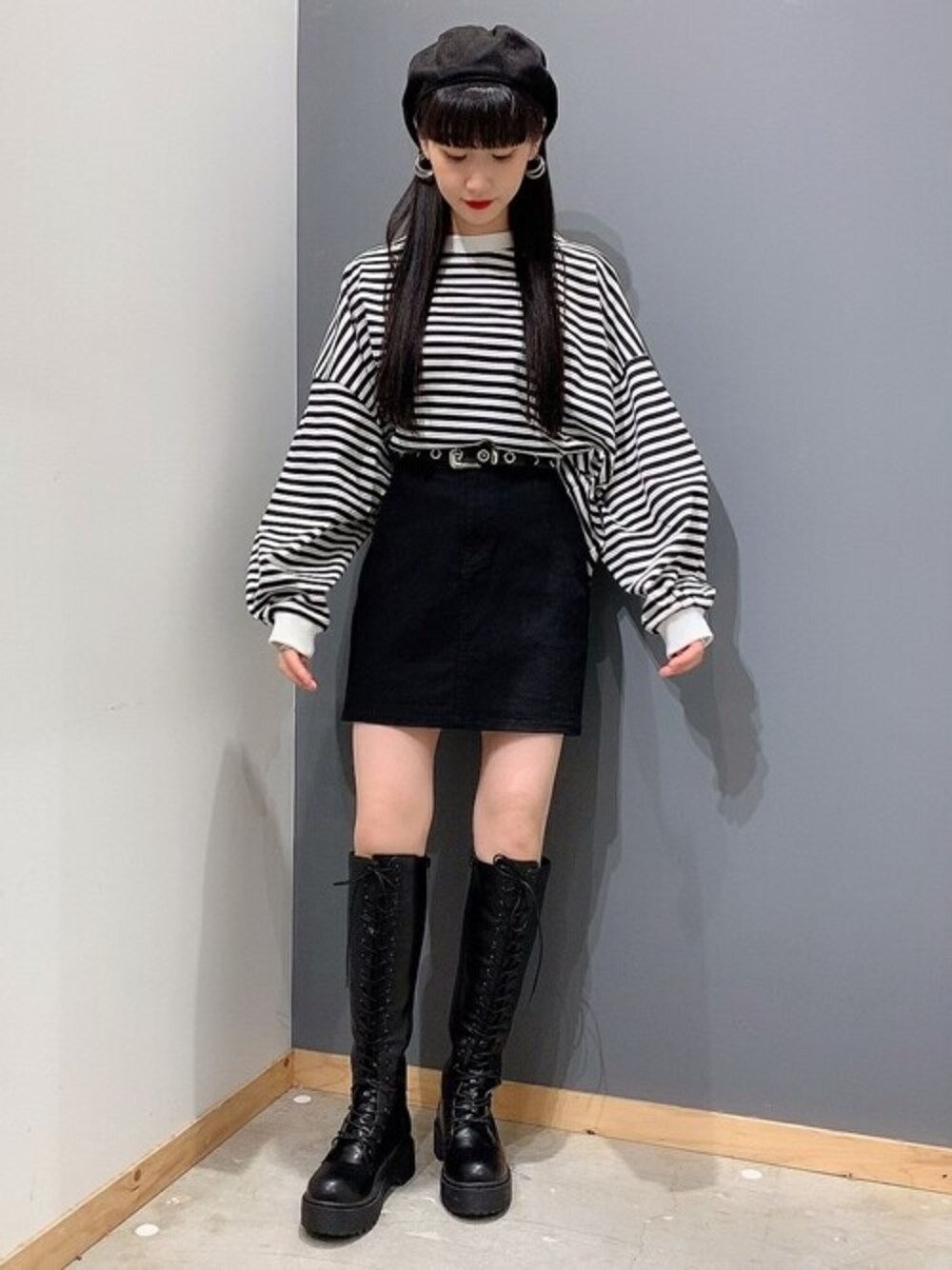 ブラック系のTシャツ/カットソー、ブラック系のスカート、ブラック系のブーツを着用したレディースの秋コーディネートの1枚目の写真