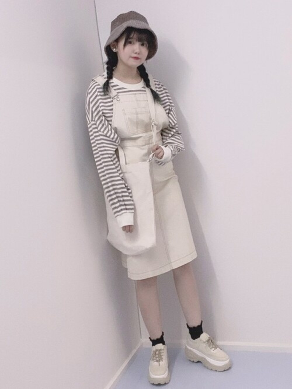 ベージュ系のTシャツ/カットソー、ホワイト系のジャンパースカート、その他のトートバッグを着用したレディースの秋コーディネートの1枚目の写真