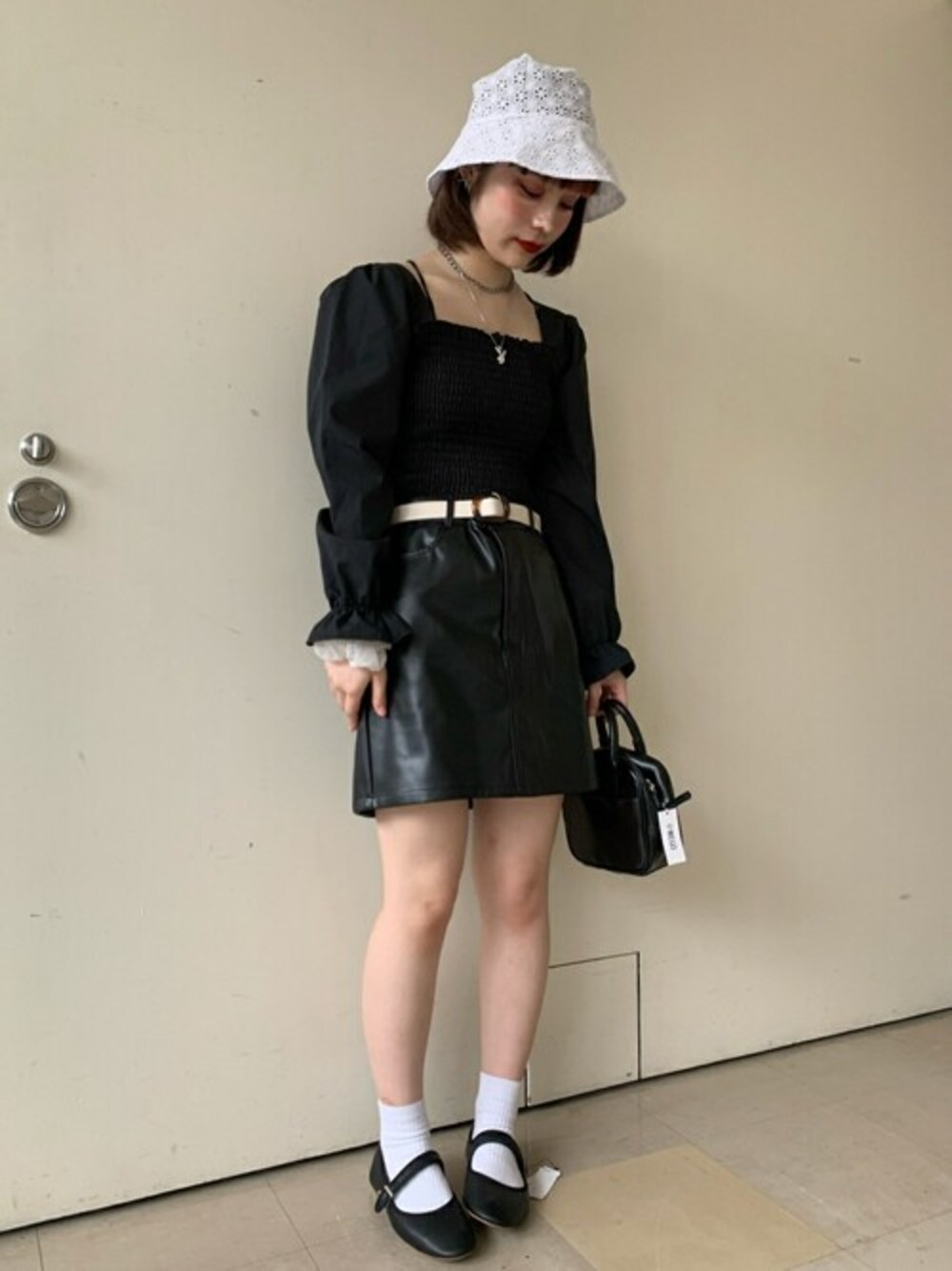 ブラック系のスカート、ブラック系のシャツ/ブラウス、ブラック系のショルダーバッグを着用したレディースの秋コーディネートの1枚目の写真