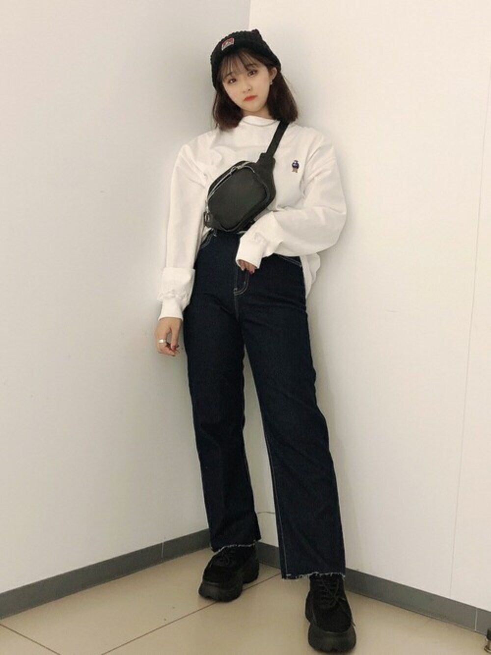 ホワイト系のTシャツ/カットソー、ブルー系のデニムパンツ、ブラック系のスニーカーを着用したレディースの秋コーディネートの1枚目の写真