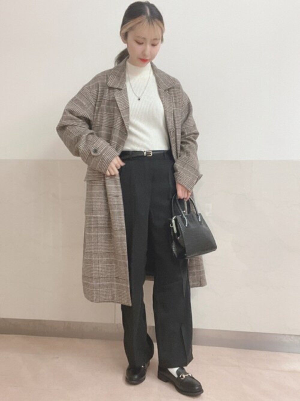 ホワイト系のニット/セーター、ブラック系のスラックス、ベージュ系のチェスターコートを着用したレディースの秋コーディネートの1枚目の写真