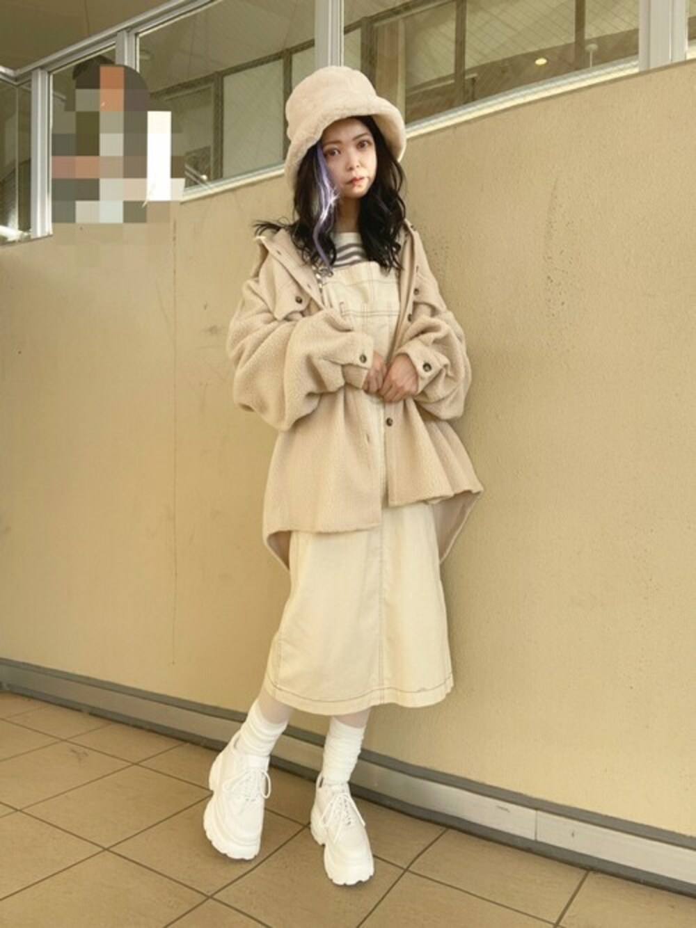 ベージュ系のスウェット、ホワイト系のジャンパースカート、ホワイト系のスニーカーを着用したレディースの秋コーディネートの1枚目の写真