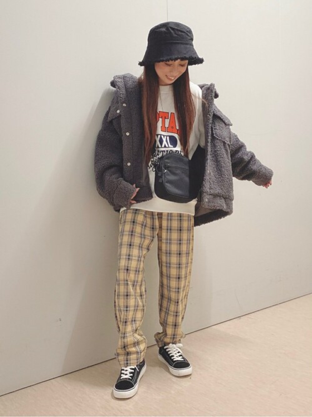 ベージュ系のスラックス、ブラック系のスニーカー、ブラック系のブルゾンを着用したレディースの秋コーディネートの1枚目の写真