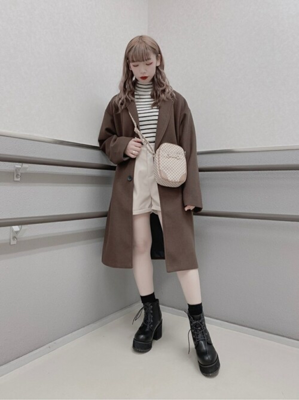 ホワイト系のニット/セーター、ベージュ系のその他パンツ、ブラウン系のチェスターコートを着用したレディースの冬コーディネートの1枚目の写真