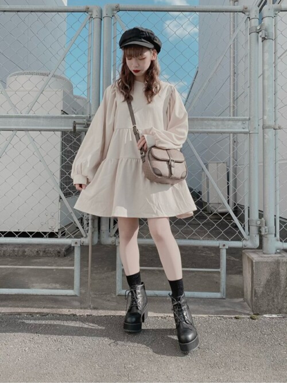 ホワイト系のワンピース、ブラック系のブーツ、ベージュ系のショルダーバッグを着用したレディースの冬コーディネートの1枚目の写真