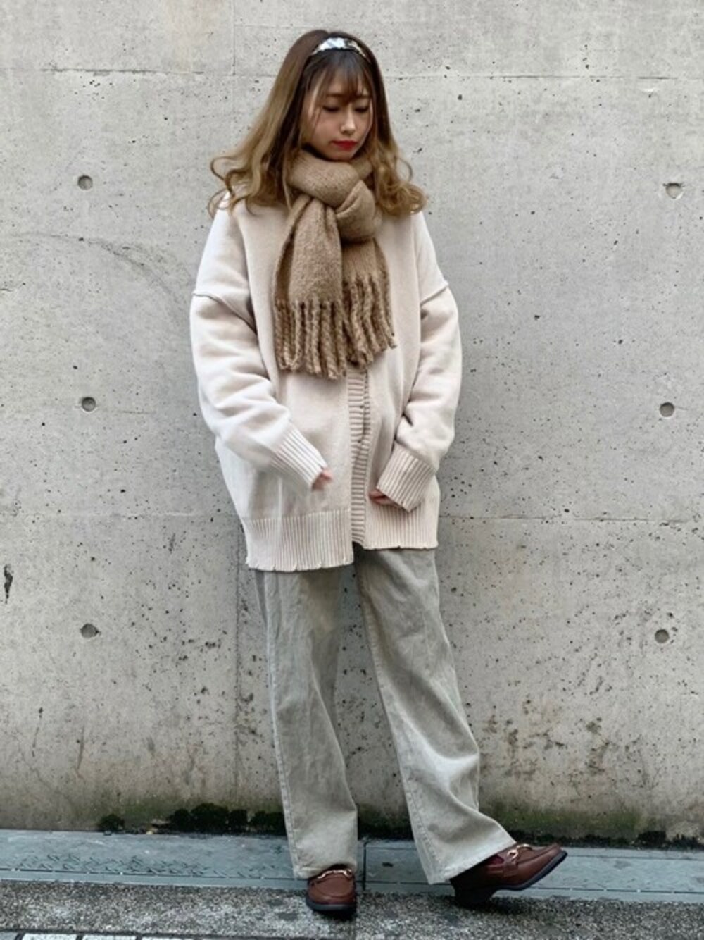 グリーン系のスラックス、ホワイト系のスウェット、ブラウン系のローファーを着用したレディースの冬コーディネートの1枚目の写真
