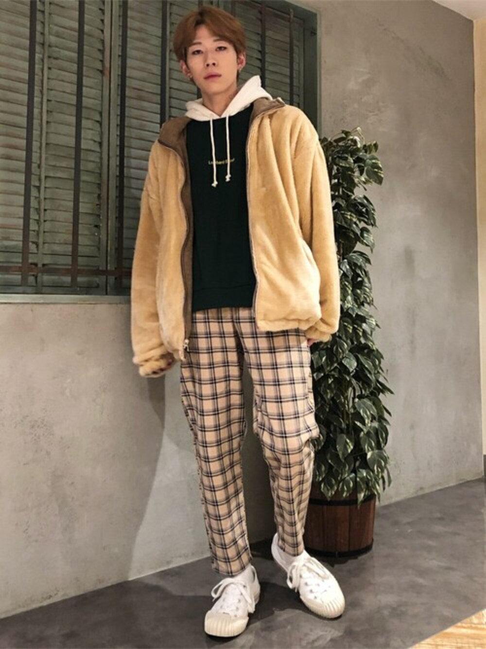 ブラウン系のブルゾン、ベージュ系のチノパンツ、グリーン系のパーカーを着用したレディースの冬コーディネートの1枚目の写真