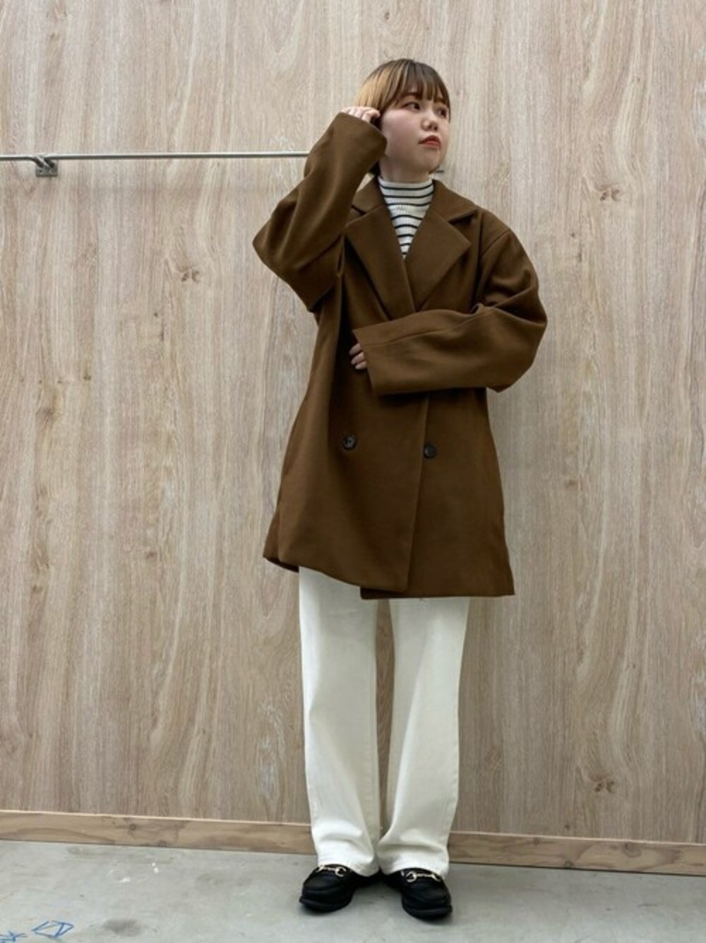 ブラウン系のテーラードジャケット、ホワイト系のニット/セーター、ホワイト系のデニムパンツを着用したレディースの冬コーディネートの1枚目の写真