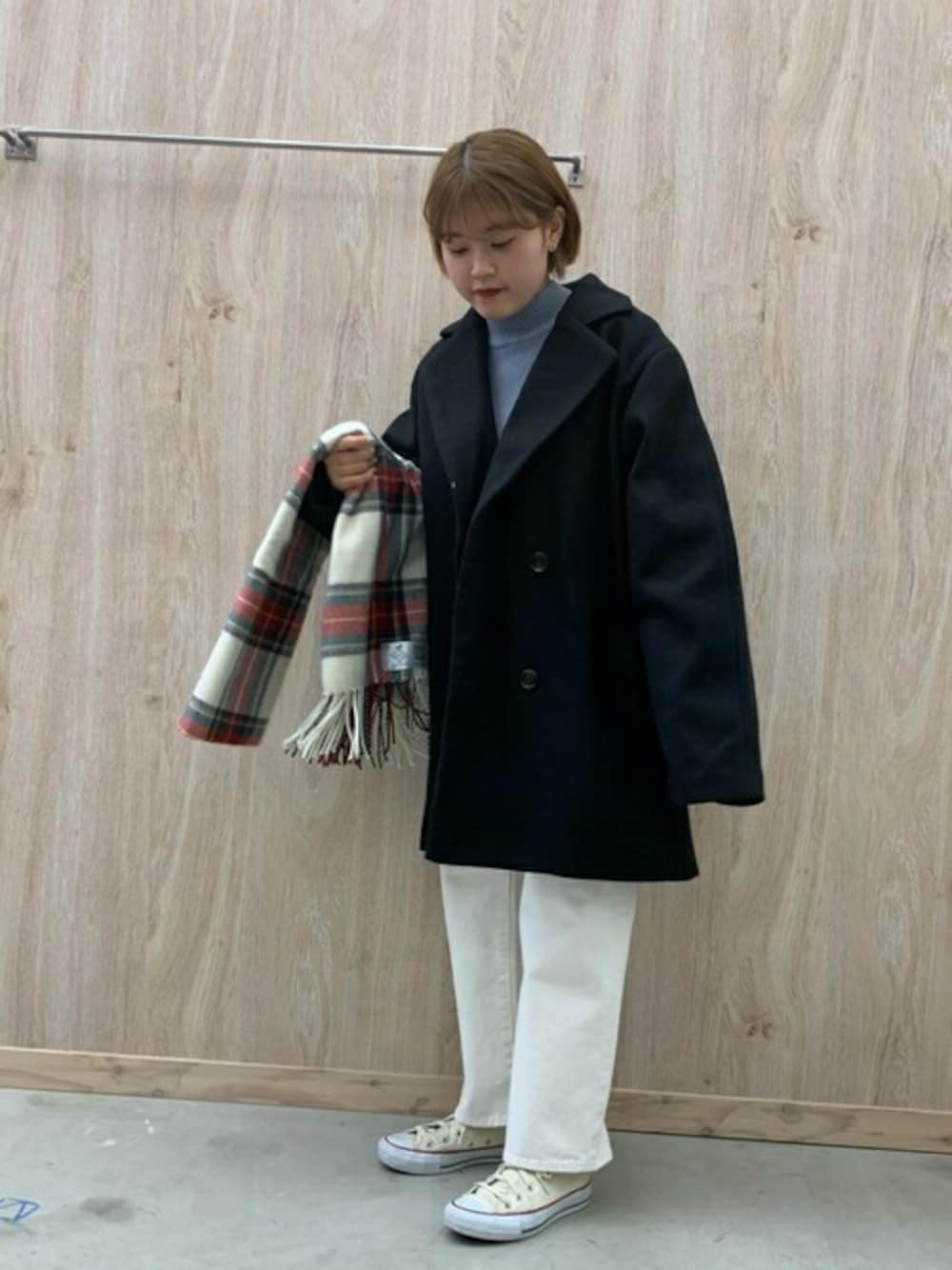 ブラック系のテーラードジャケット、ブルー系のニット/セーター、ホワイト系のデニムパンツを着用したレディースの冬コーディネートの1枚目の写真