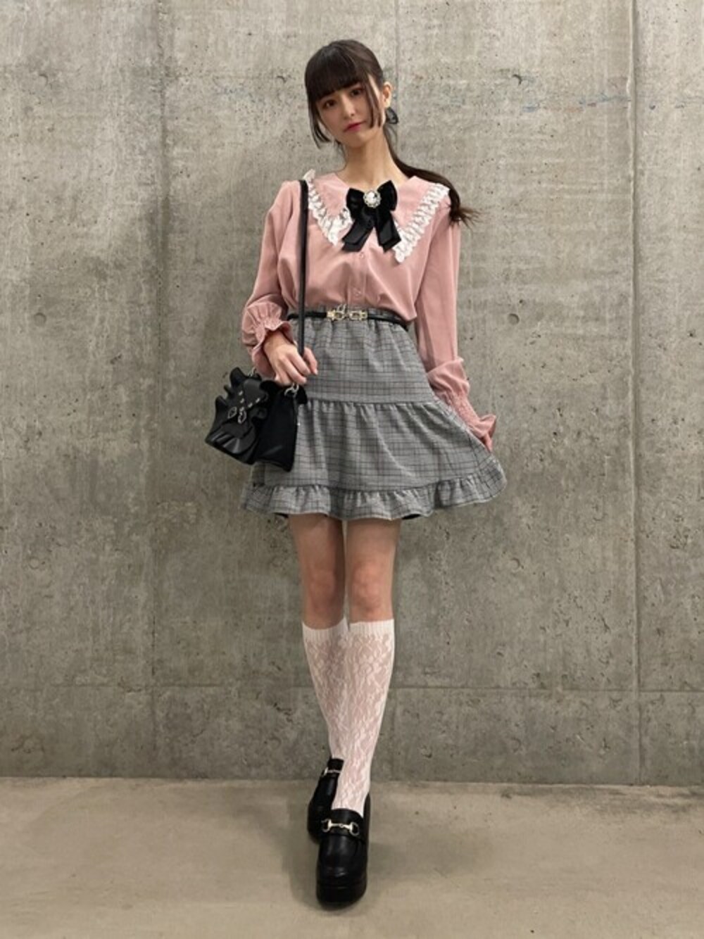 その他のショルダーバッグ、その他のドレスシューズ、グレー系のスカートを着用したレディースの冬コーディネートの1枚目の写真