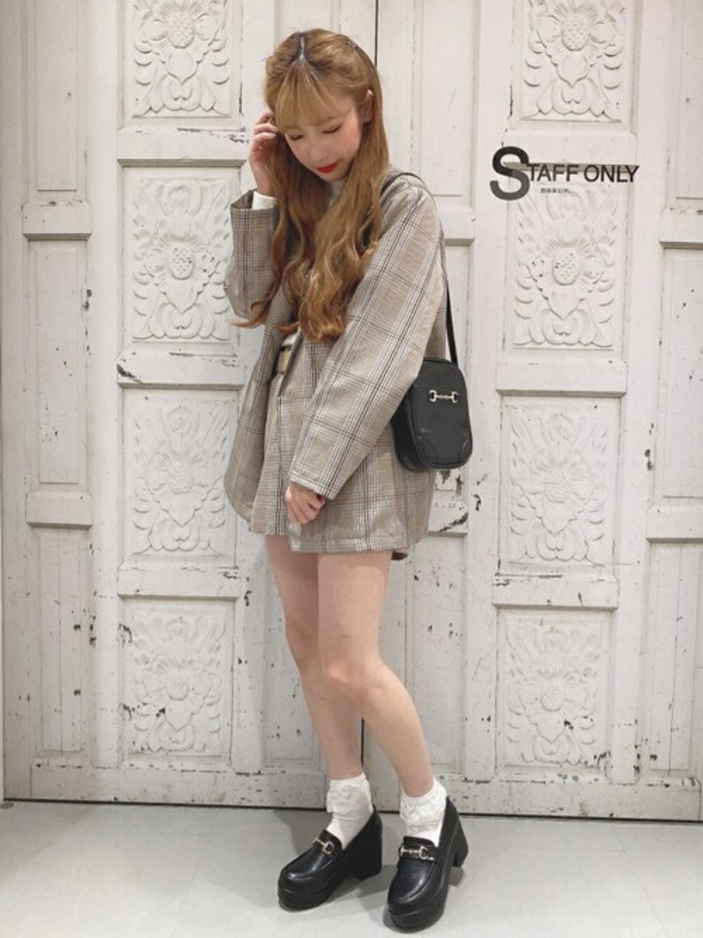 ブラック系のショルダーバッグ、ベージュ系のテーラードジャケット、ホワイト系のニット/セーターを着用したレディースの冬コーディネートの1枚目の写真