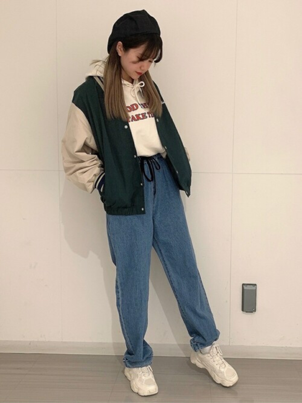 グリーン系のブルゾン、ホワイト系のパーカー、ブルー系のスラックスを着用したレディースの春コーディネートの1枚目の写真