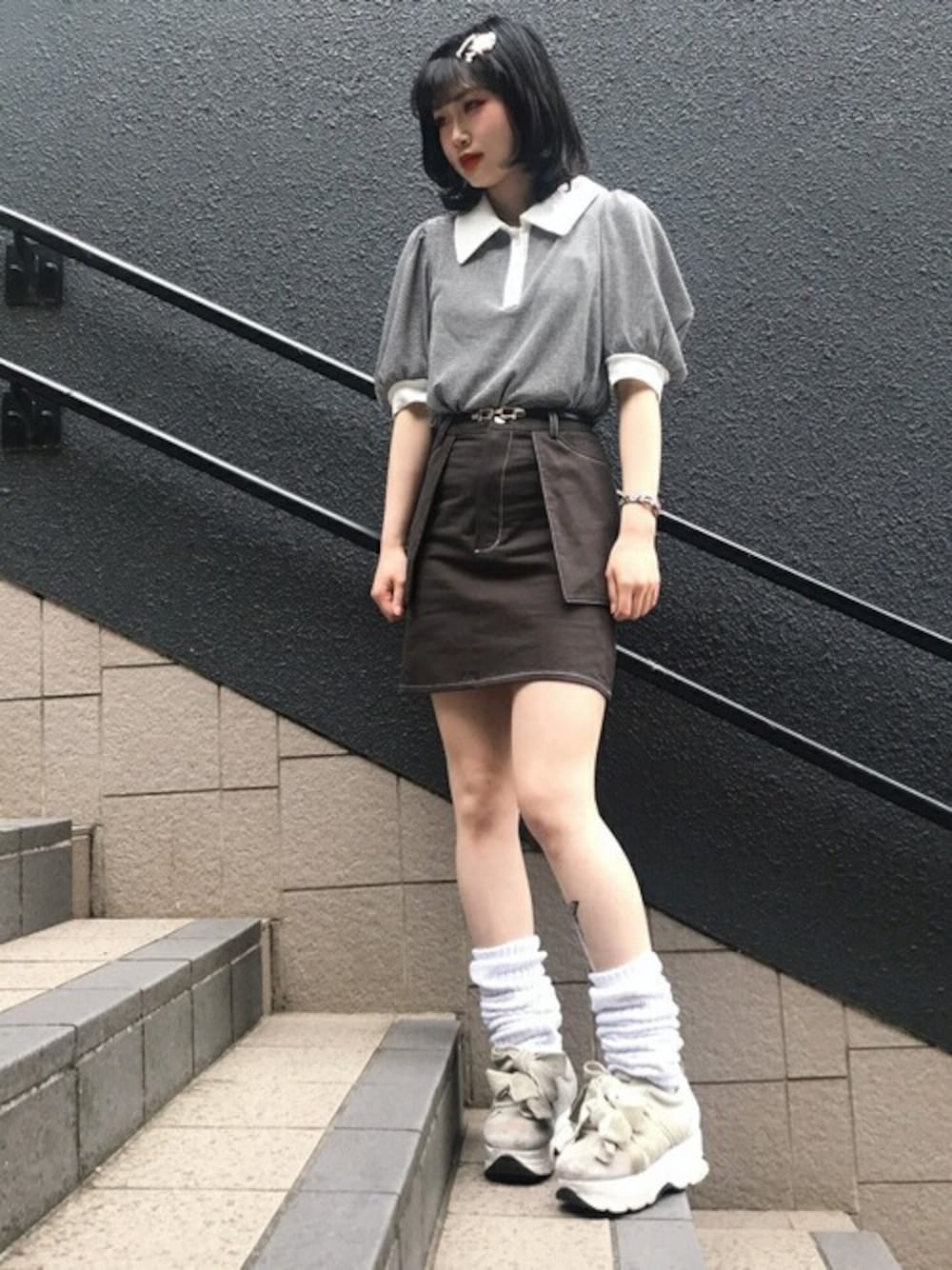 ブラック系のスカート、ブラック系のポロシャツを着用したレディースの春コーディネートの1枚目の写真