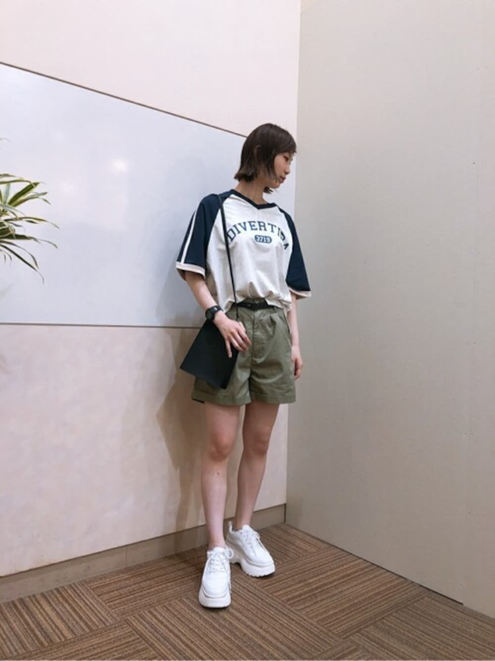 グリーン系のチノパンツ、ベージュ系のTシャツ/カットソー、ホワイト系のスニーカーを着用したレディースの春コーディネートの1枚目の写真