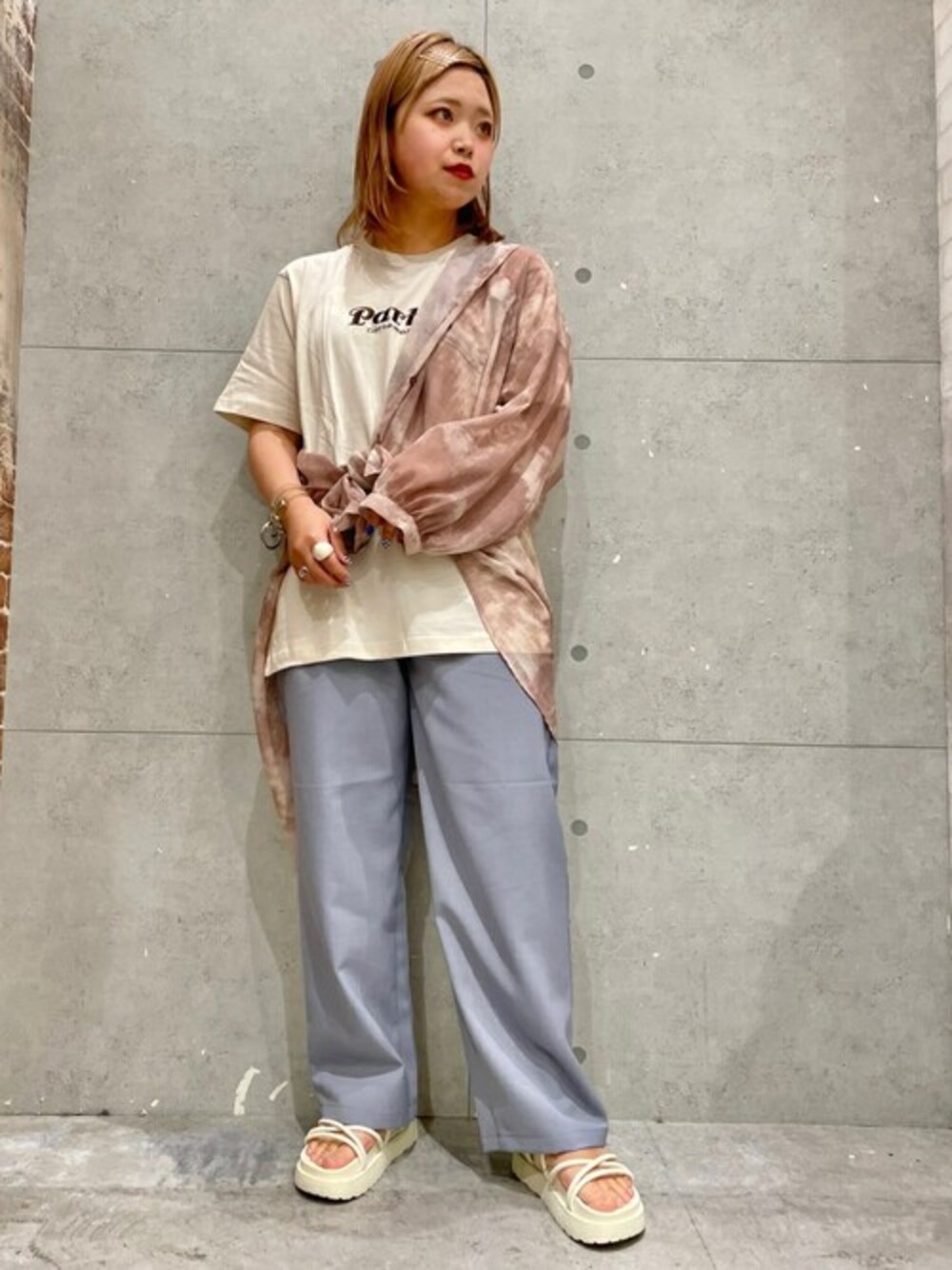 ホワイト系のTシャツ/カットソー、ホワイト系のサンダル、ブルー系のスラックスを着用したレディースの春コーディネートの1枚目の写真