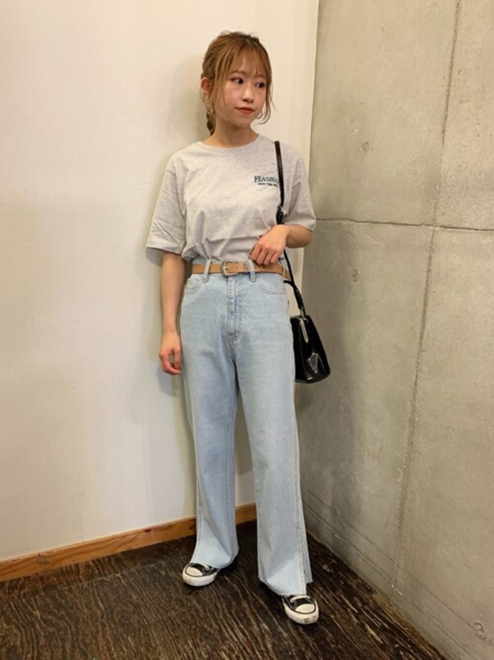 ブルー系のデニムパンツ、ブラック系のショルダーバッグ、グレー系のTシャツ/カットソーを着用したレディースの春コーディネートの1枚目の写真