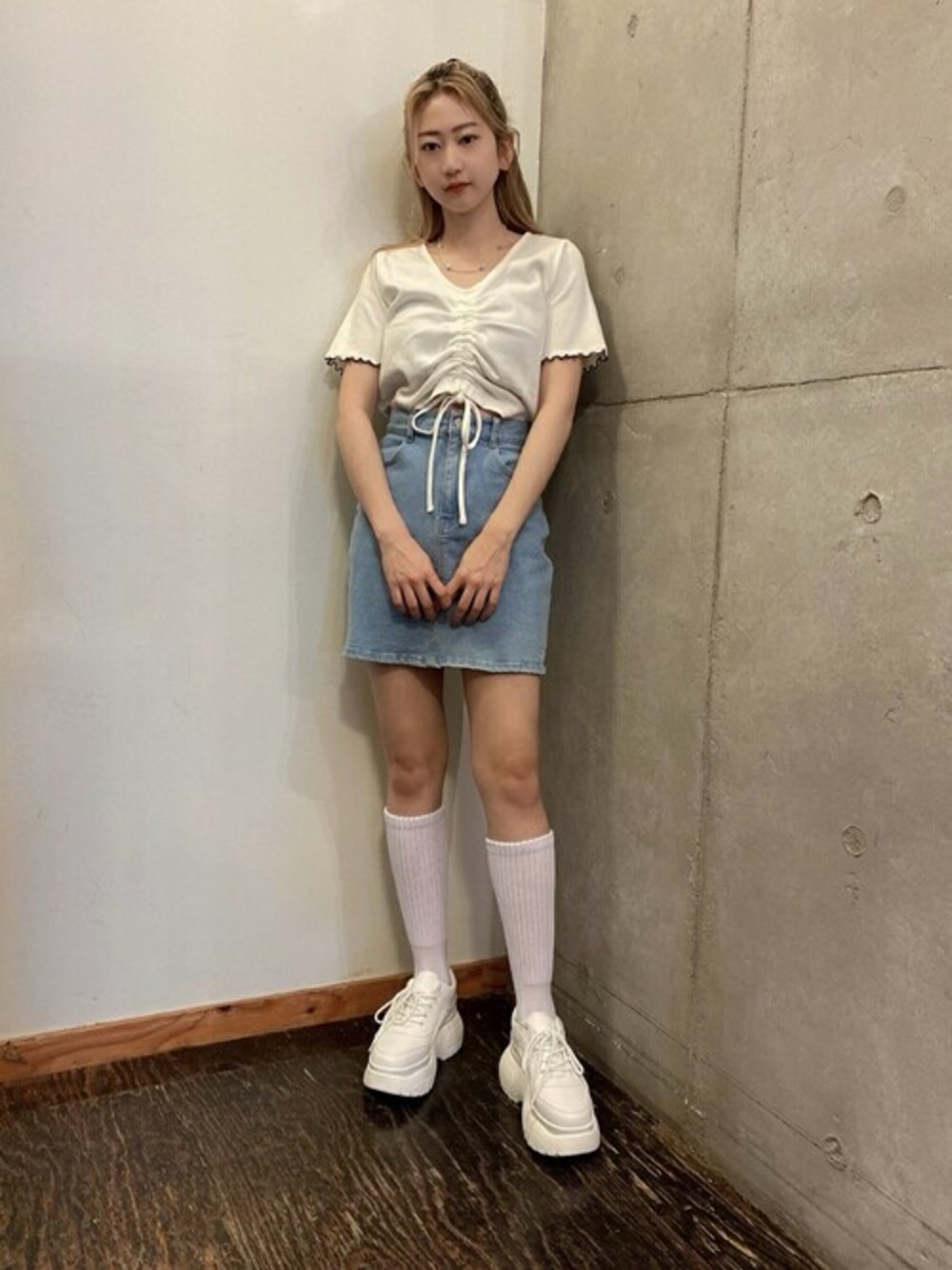 ブルー系のデニムスカート、ホワイト系のTシャツ/カットソー、ホワイト系のスニーカーを着用したレディースの春コーディネートの1枚目の写真