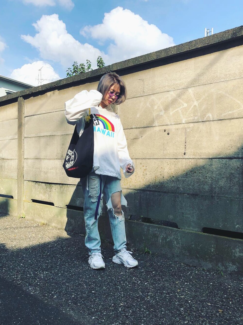 ホワイト系のスニーカー、ブルー系のデニムパンツ、ホワイト系のブルゾンを着用したレディースの秋コーディネートの1枚目の写真