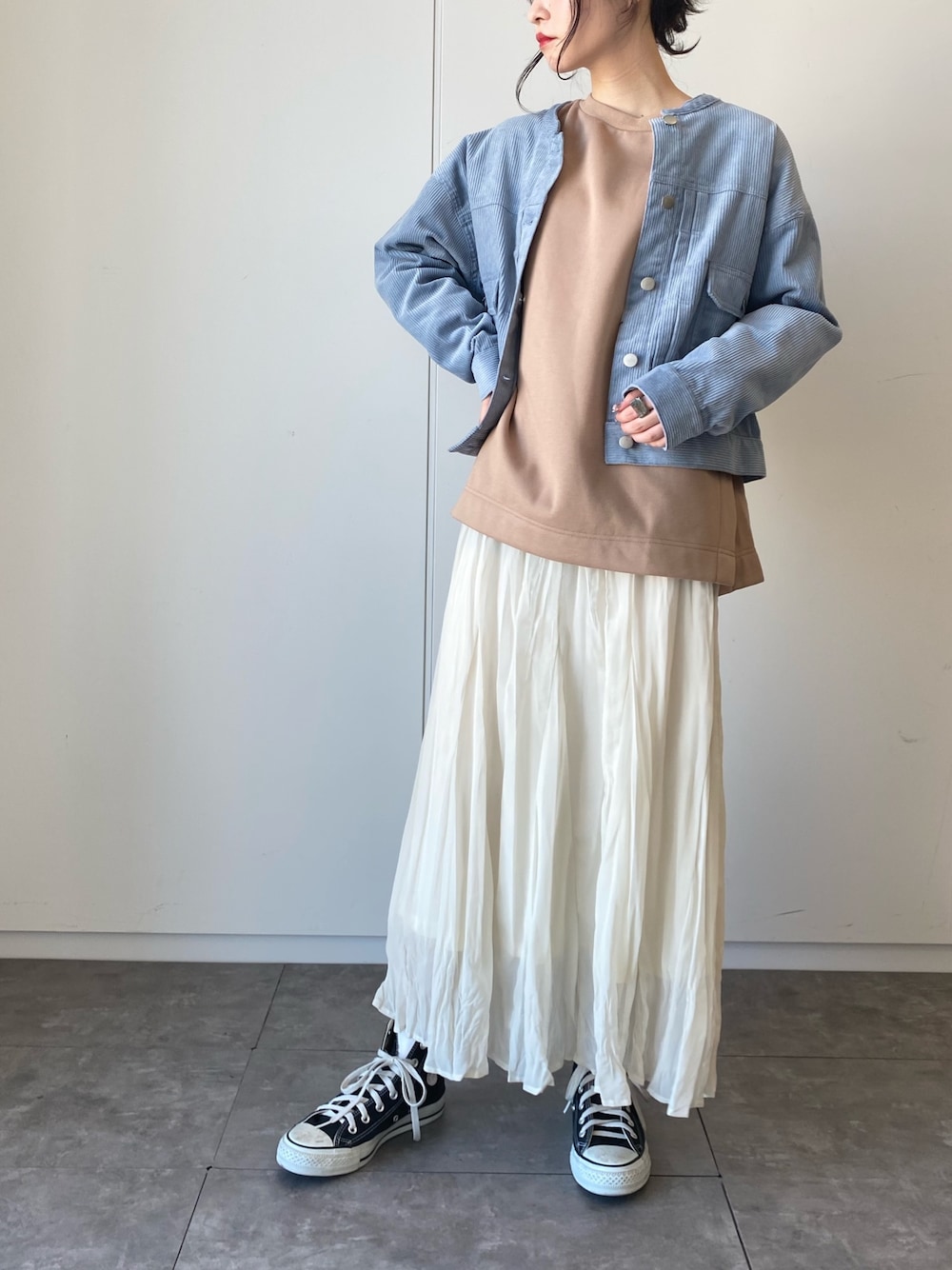ブルー系のブルゾン、ベージュ系のTシャツ/カットソー、ホワイト系のスカートを着用したレディースの冬コーディネートの1枚目の写真