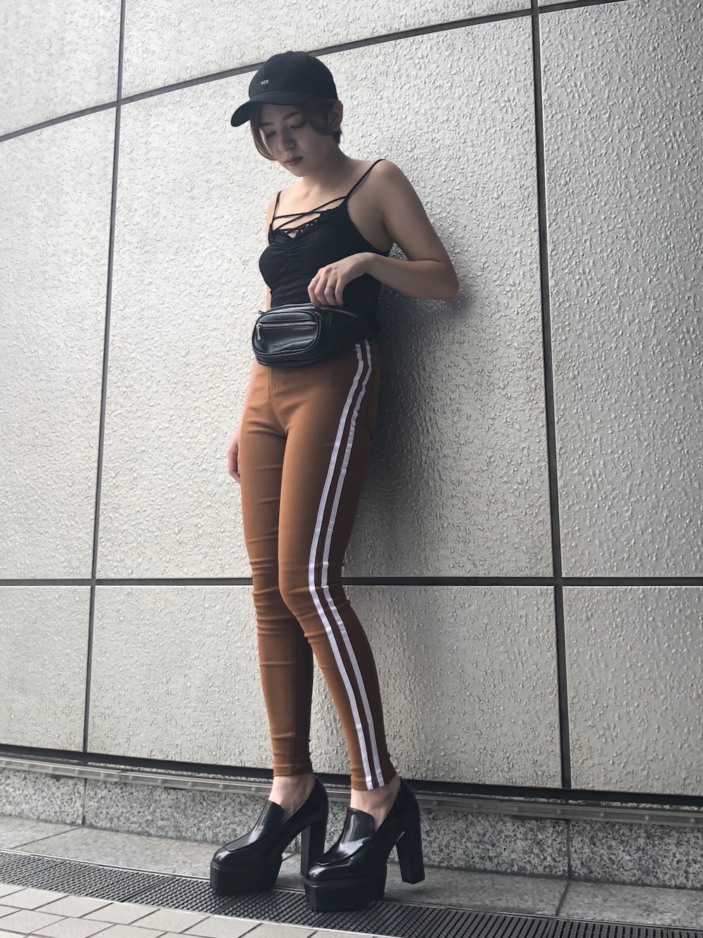 ブラック系のキャミソール、ブラウン系のパンツ、ブラック系のローファーを着用したレディースの夏コーディネートの1枚目の写真