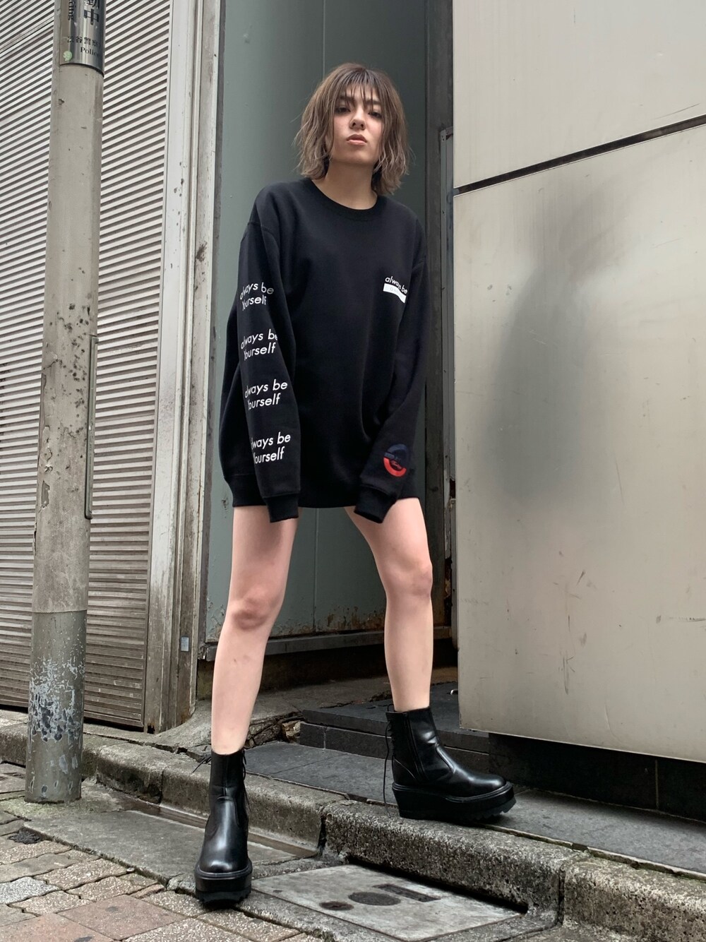 ブラック系のスウェット、ブラック系のブーツ、ベージュ系のその他パンツを着用したレディースの春コーディネートの1枚目の写真