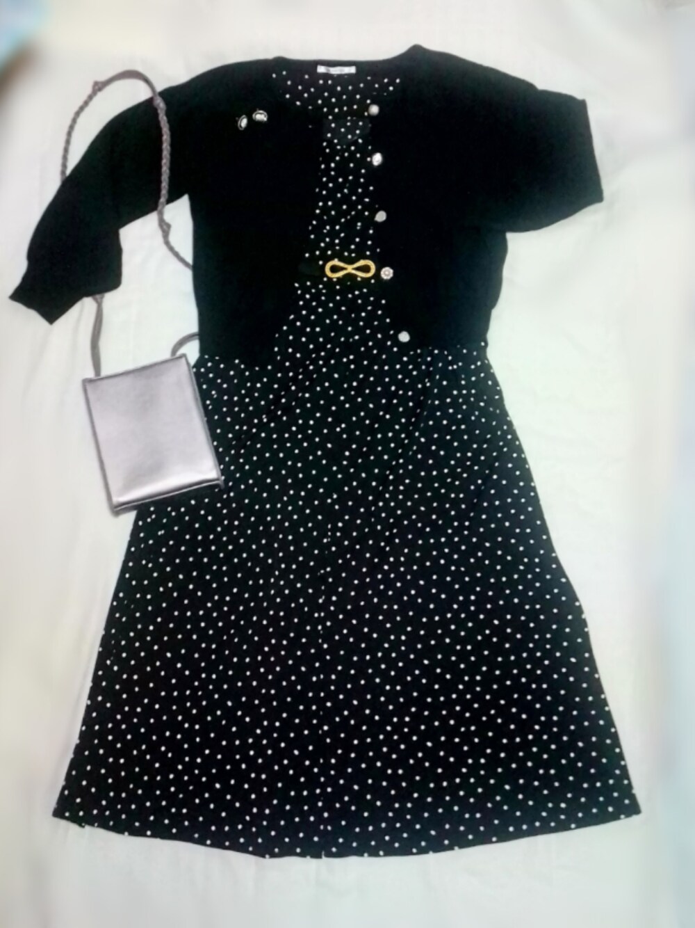 ブラック系のワンピース、シルバー系のショルダーバッグ、ブラック系のカーディガン/ボレロを着用したレディースの秋コーディネートの1枚目の写真