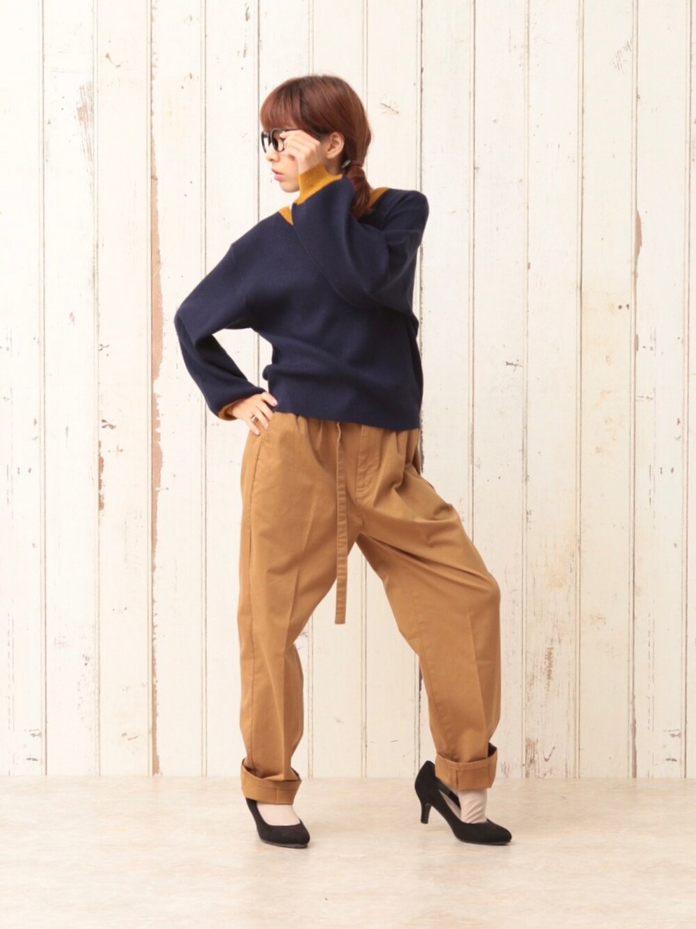 ブルー系のニット/セーター、イエロー系のスラックス、ブラック系のパンプスを着用したレディースの冬コーディネートの1枚目の写真