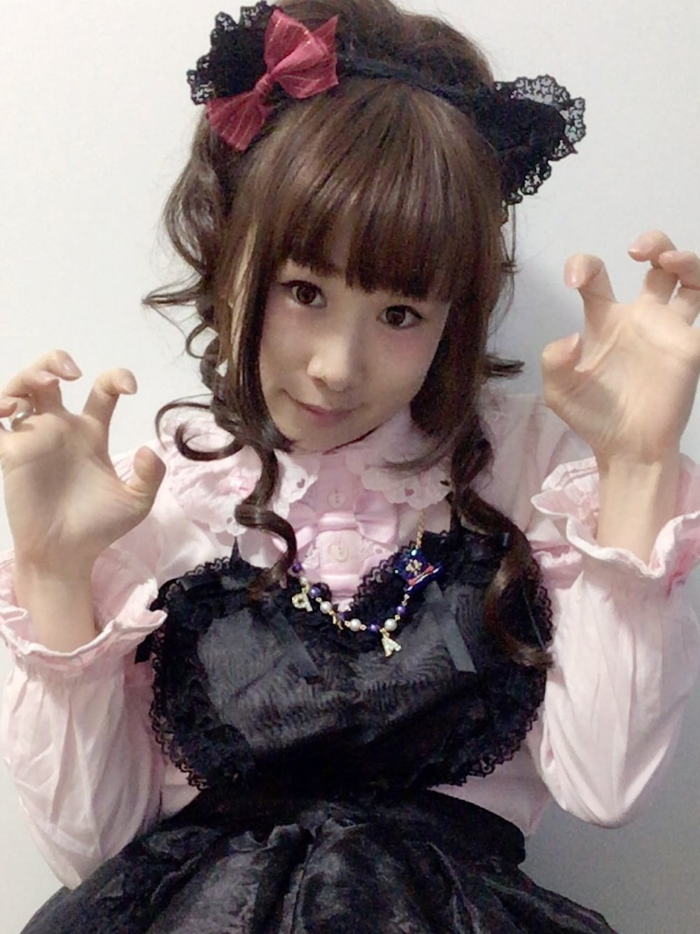 ピンク系のシャツ/ブラウス、ブラック系のエプロン、ブラウン系のヘアアクセサリーを着用したレディースの秋コーディネートの1枚目の写真