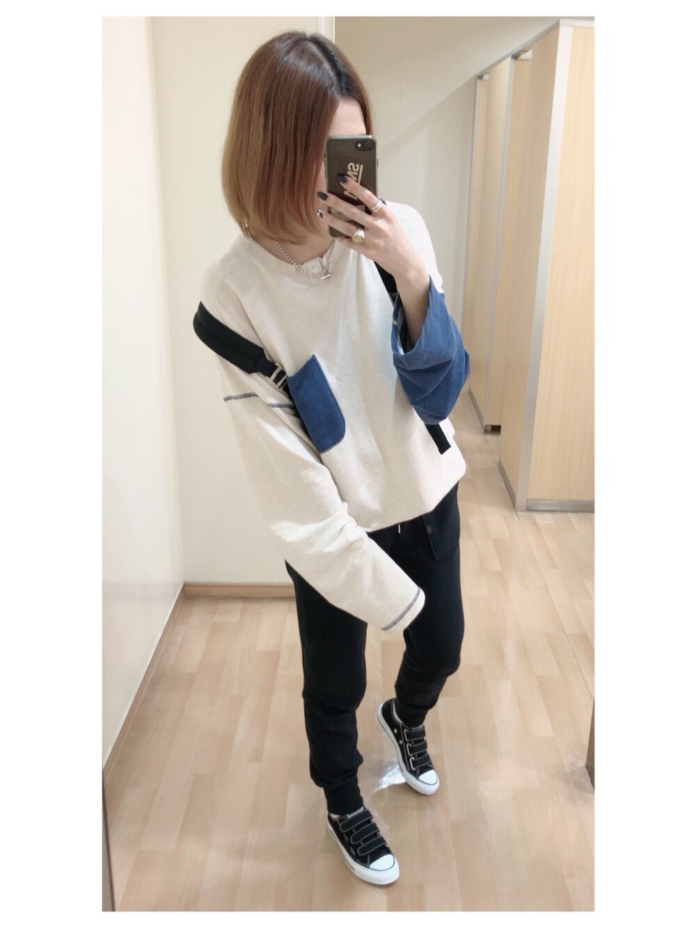 ブラック系のパンツ、ブラック系のスニーカー、ブラック系のショルダーバッグを着用したレディースの秋コーディネートの1枚目の写真