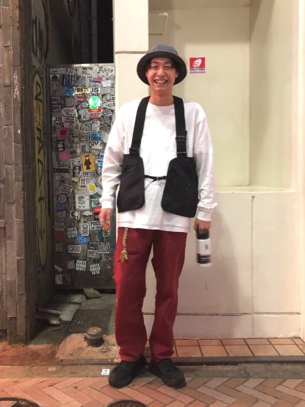 パープル系のTシャツ/カットソー、ブラック系のベスト、ブラック系のシューズを着用したメンズの春コーディネートの1枚目の写真